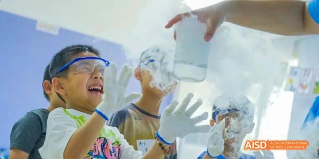 A student at Beijing Limai (International) School smiles while performing a science experiment.