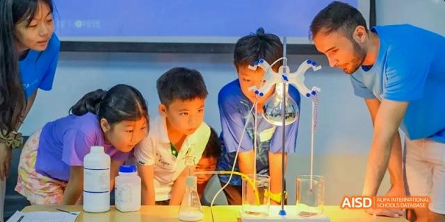 Students at Beijing Limai (International) School work with beakers in a lab.