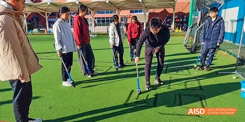 Students at Beijing Limai (International) School play a game of cricket.