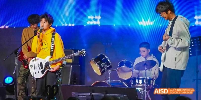 Students at Beijing Limai (International) School perform on stage with musical instruments.