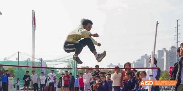 A student at Beijing Limai (International) School jumps over a net during an activity.