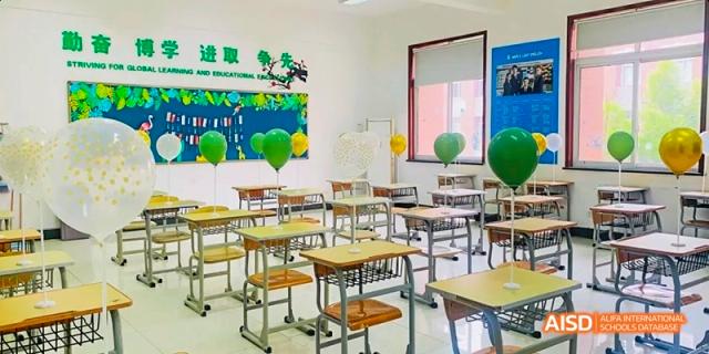 An image of an empty classroom with student desks and chairs neatly arranged, decorated with balloons, at Maple Leaf International School Chongqing.