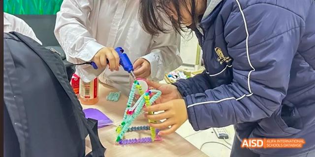 A close-up of a student working on a hands-on project using colorful interlocking building pieces during a lesson at Maple Leaf International School Chongqing.