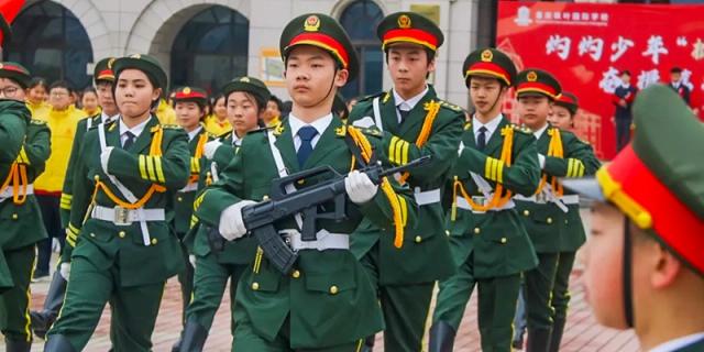 Students in Chinese military-style uniforms marching as part of a parade or training exercise at Maple Leaf International School Chongqing.
