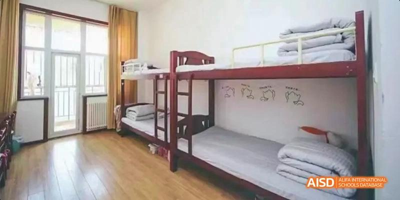 An image showing empty wooden bunk beds in a dormitory room at Maple Leaf International School Chongqing.