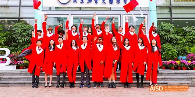 Canadian International School of Beijing graduates celebrating together and posing in front of a building.