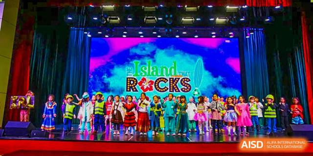 A Canadian International School of Beijing school play or musical performance on a stage with the banner "Island Rocks" in the background.