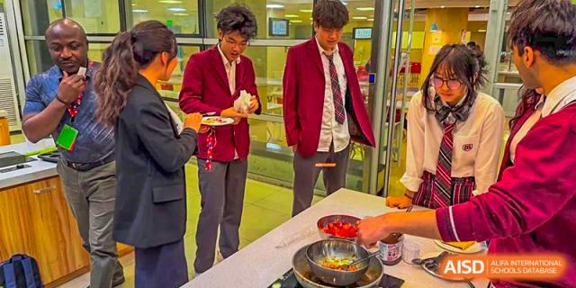 Canadian International School of Beijing students in red jackets serve themselves from a buffet line.