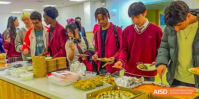 A Canadian International School of Beijing male student looks at the food options on a buffet table.
