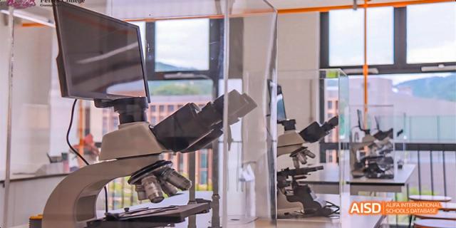 An optical microscope sitting on a lab bench in a science laboratory at Fettes College Guangzhou.