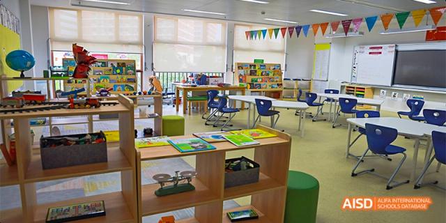 An image of a colorful, open-plan Junior School classroom at Fettes College Guangzhou with various learning stations and small tables.