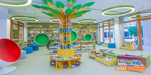 A view of the bright and colorful Junior School library at Fettes College Guangzhou, featuring a unique tree-shaped bookshelf.