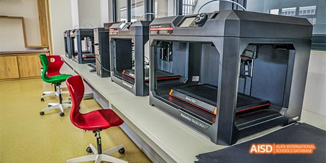 A close-up of advanced 3D printing equipment or heavy-duty machinery in a workshop or laboratory at Fettes College Guangzhou.