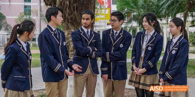 Three Guangzhou Huamei International School students in formal school uniforms standing outside, posing for a photo.