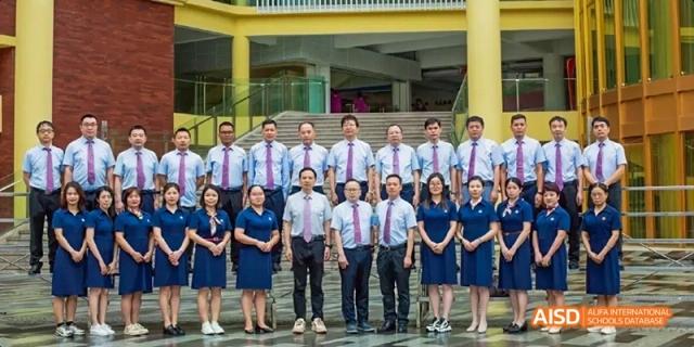 A group photo of Guangzhou Huamei International School teachers or staff members dressed in professional attire.