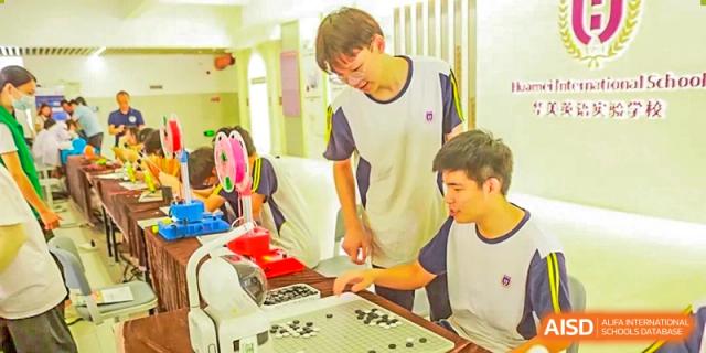 Guangzhou Huamei International School students focused on a game of Go on a board.