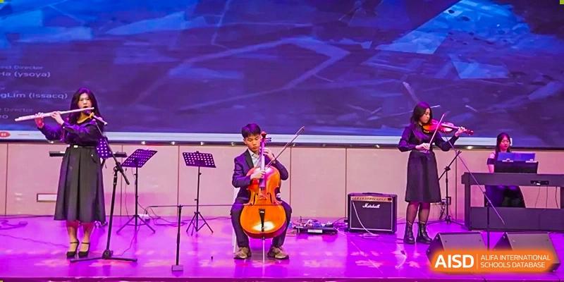A Guangzhou Huamei International School student playing the cello on stage during a performance.