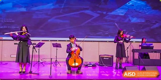 A Guangzhou Huamei International School student playing the cello on stage during a performance.