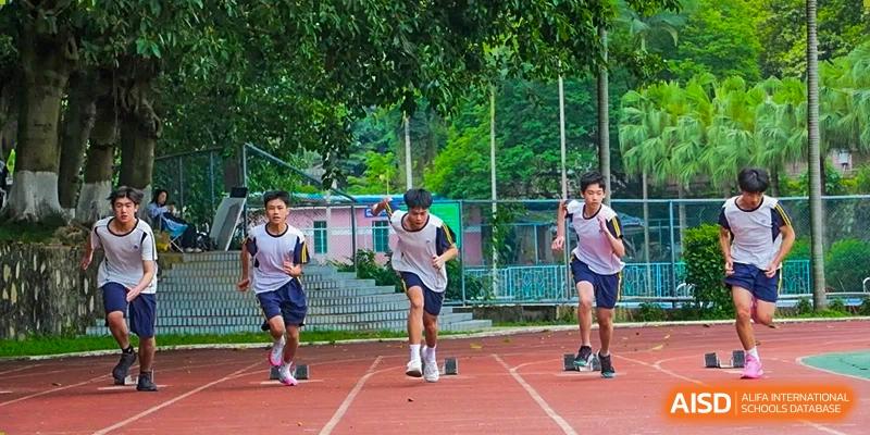 Guangzhou Huamei International School students starting a running race on a track with starting blocks.