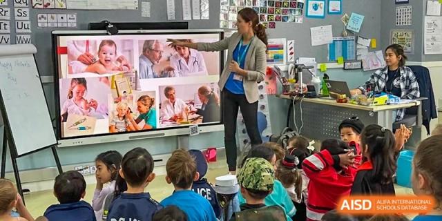 A photo showing a teacher teaching a group of students in a classroom, at The British School of Beijing, Shunyi.