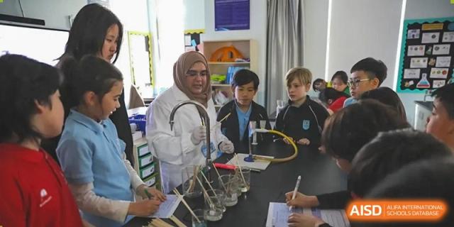 A photo showing a group of students sitting at a table and doing an art project, at The British School of Beijing, Shunyi.