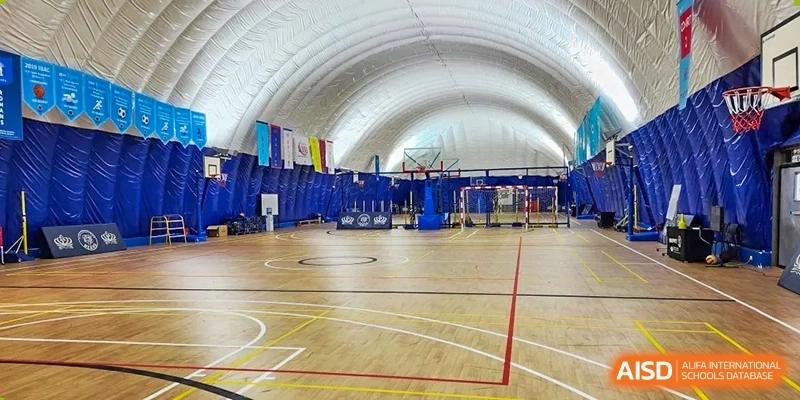 A photo showing a sports hall with a basketball court, at The British School of Beijing, Shunyi.