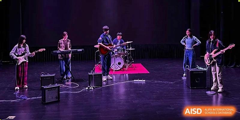 A photo showing a musical band performing on a stage, at The British School of Beijing, Shunyi.