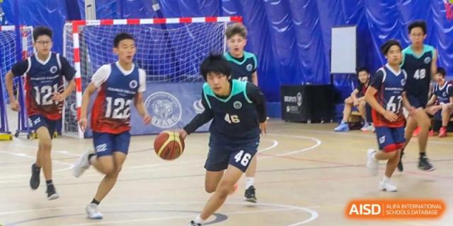 A photo showing a male student playing basketball, at The British School of Beijing, Shunyi.