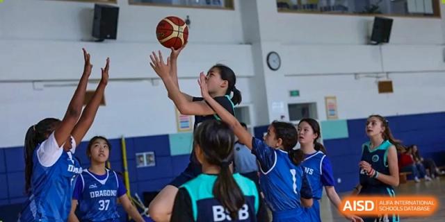 A photo showing a female student playing basketball, at The British School of Beijing, Shunyi.