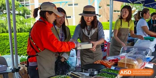 A photo showing students preparing food in a group, at The British School of Beijing, Shunyi.