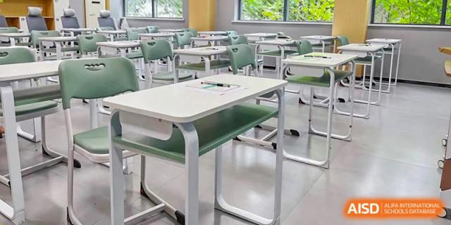 An empty classroom with desks and chairs, likely at Zhengzhou No.9 High School International Department.