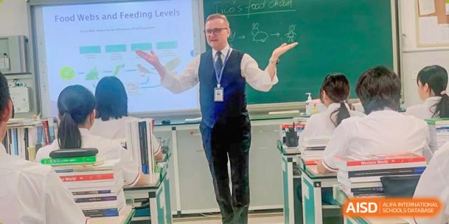 A foreign teacher enthusiastically presenting a lesson in a classroom at Zhengzhou No.9 High School International Department.