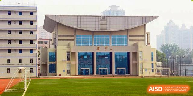 The exterior of a modern building, possibly an auditorium or gymnasium, at Zhengzhou No.9 High School International Department.