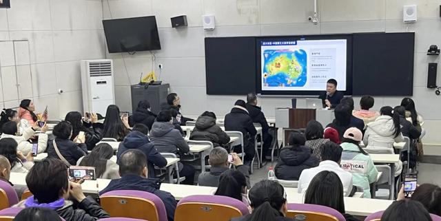 A lecture hall or large classroom at Zhengzhou No.9 High School International Department filled with students looking at a large screen.