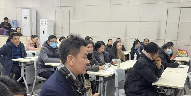 Adults and parents seated and attentively listening during a meeting or lecture at Zhengzhou No.9 High School International Department.