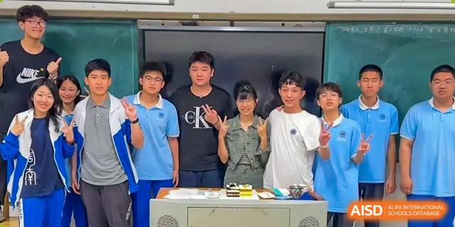 Four male students from Zhounan High School standing in front of a whiteboard in a classroom.