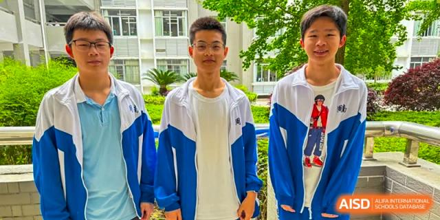 A male student from Zhounan High School smiling outdoors in a blue and white uniform.