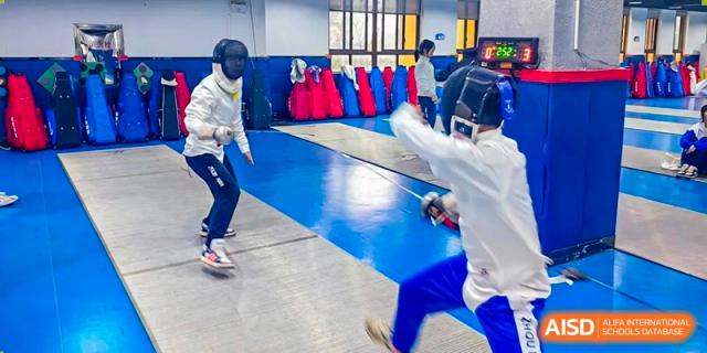 A student from Zhounan High School engaging in a fencing match on a blue piste.