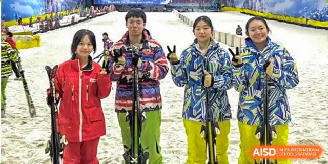 Two students from Zhounan High School in winter sports gear, holding skis or poles.