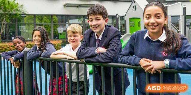 Two students are leaning on a railing and smiling. Hangzhou Dipont School of Arts and Science.
