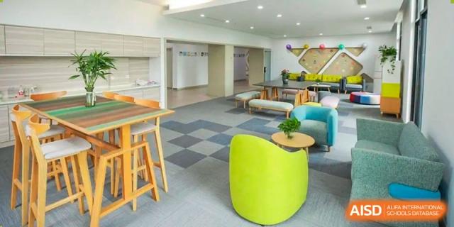 A bright and modern student common area with a green chair. Hangzhou Dipont School of Arts and Science.
