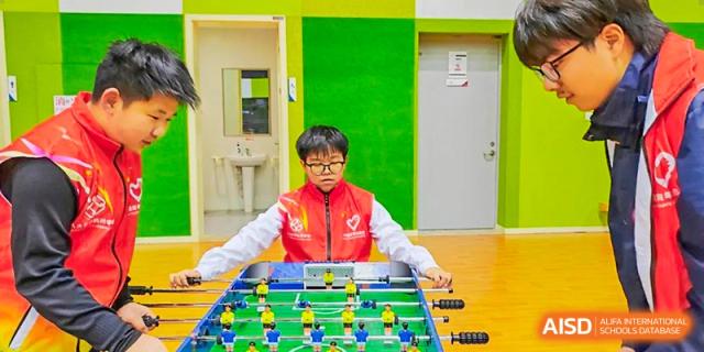 A student is playing foosball. Hangzhou Dipont School of Arts and Science.