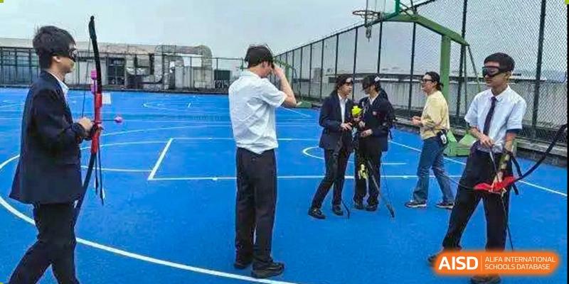 Students and staff are gathered in a group outdoors. Hangzhou Dipont School of Arts and Science.