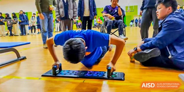 A student is lying on the floor, doing an exercise. Hangzhou Dipont School of Arts and Science.