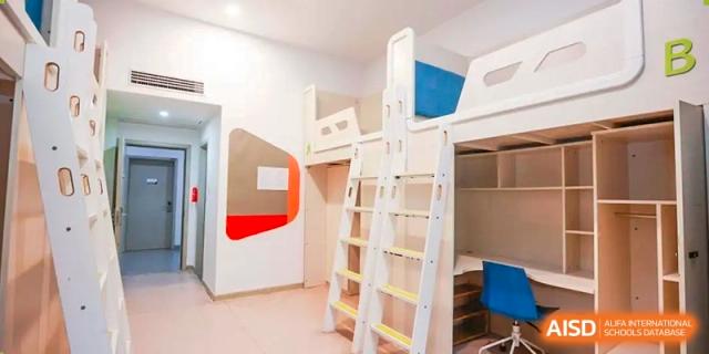A student dormitory room with a bunk bed and a desk. Hangzhou Dipont School of Arts and Science.