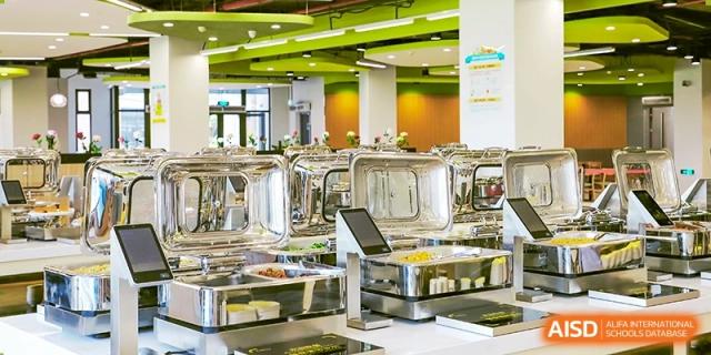 A clean and modern kitchen or food preparation area with large metal tanks. Hangzhou Dipont School of Arts and Science.