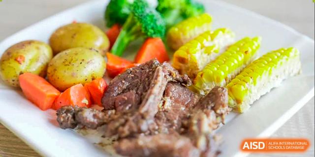 A close-up of a cooked meat dish with vegetables. Hangzhou Dipont School of Arts and Science.