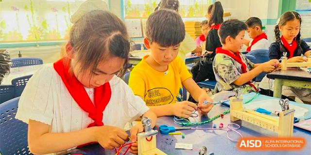 Ningbo Huamao International School students working on a hands-on project with a teacher.