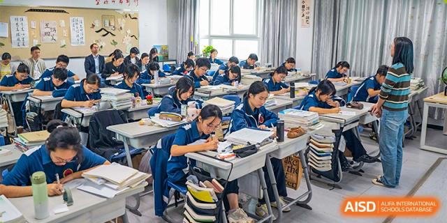 Students from Ningbo Huamao International School working on an assignment at their desks in a classroom.