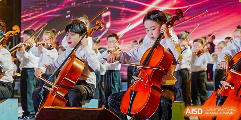 Ningbo Huamao International School students performing in an orchestra, with a cellist in the foreground.